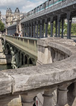 France, Paris - May 03, 2025 - Perspective of A metro train crossing the Pont de Bir Hakeim bridge with typical parisian buildings in the background. Architectural structure of The two-level bridge built (Steel bridge), use it as your Wallpaper, Poster and Space for text, Selective focus.