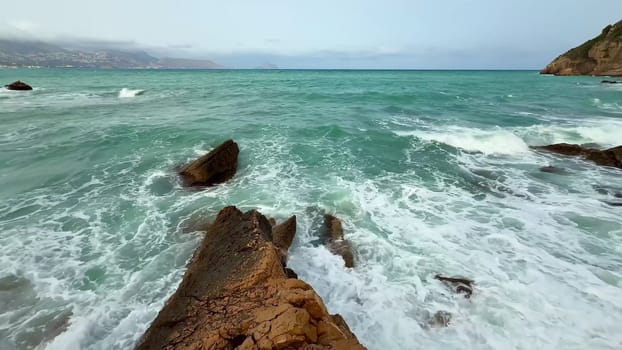 Experience the tranquil beauty of crashing waves on rugged shores in a coastal landscape that captivates the senses