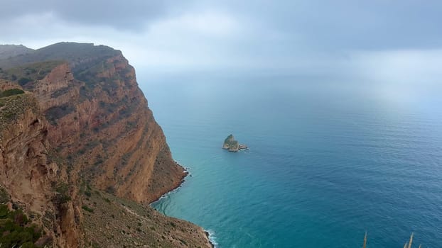 Capture the stunning beauty of rocky cliffs rising majestically by the azure sea, ideal for nature and travel themes