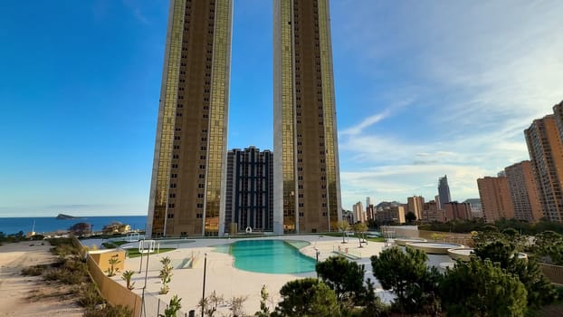 The stunning view features skyscrapers beside a shimmering pool, complemented by a picturesque ocean backdrop