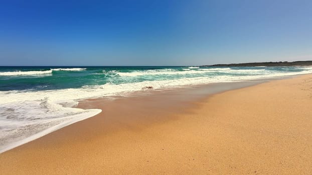 A serene and picturesque beach scene showcasing soft golden sand and clear blue waters beneath a bright sunny sky
