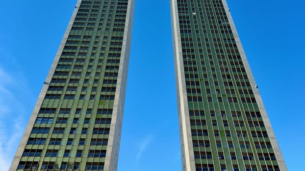 A stunning view featuring two impressive modern twin towers beautifully set against a bright blue sky