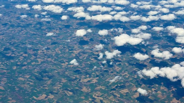 A breathtaking aerial shot beautifully showcasing the vibrant, colorful fields and soft, fluffy clouds from high above