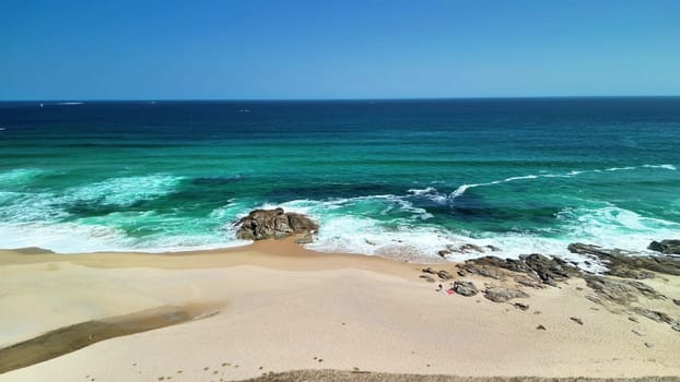 Imagine a picturesque beach with turquoise waters, golden sand, and unique rock formations that enhance its charm