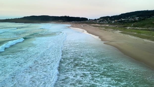 A serene and picturesque beach scene captured during sunset, showcasing gentle, soft waves and golden sandy shores