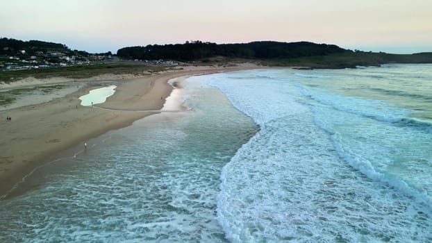 A serene and peaceful beach scene at dusk featuring gently rolling soft waves, golden sands, and a quiet shoreline