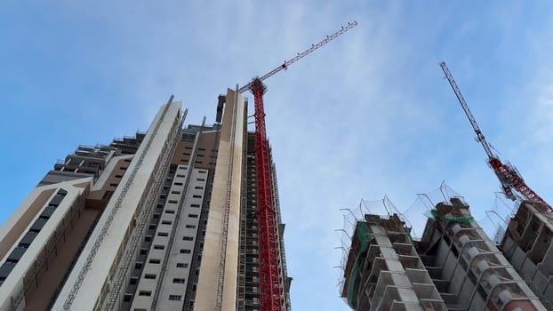 A dynamic and vivid view of a bustling construction site featuring tall buildings alongside active tower cranes