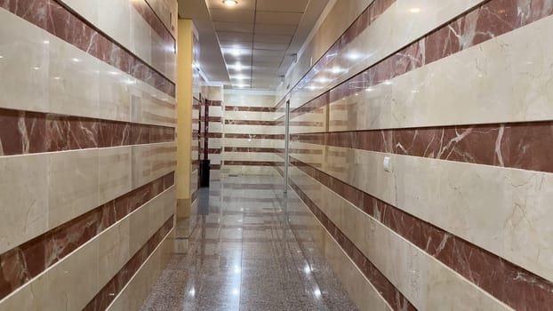 A sleek and modern hallway featuring chic marble wall designs that are perfect for various types of commercial spaces