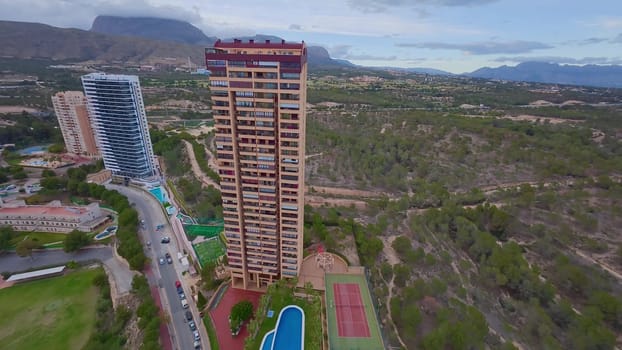 An aerial perspective showcases highrise buildings set against the backdrop of beautiful natural landscapes
