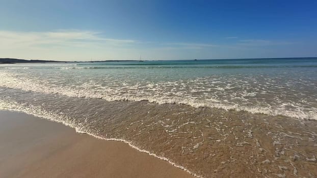 A serene beach view with gentle waves glistening under a radiant blue sky, ideal for ultimate relaxation