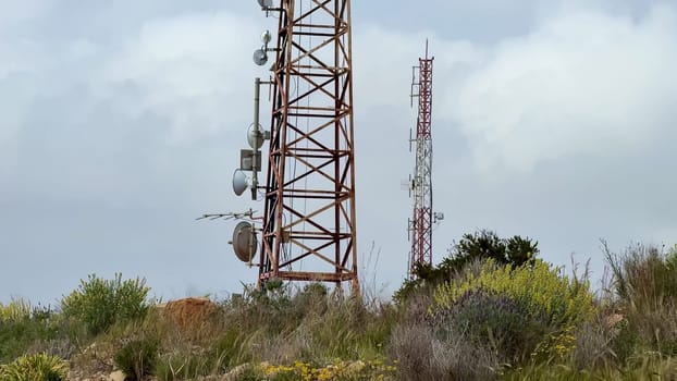 Here is a detailed and closeup view of a telecommunication tower that features many antennas and essential equipment