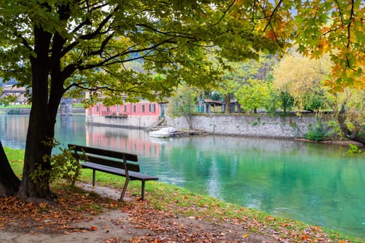 Outdoor wood chair in front of the river, empty bench, Italian rural atmosphere