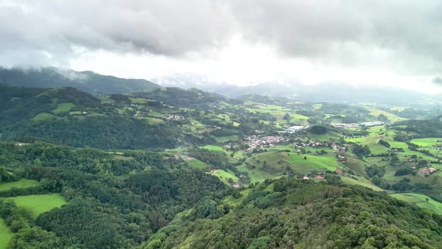 A stunning aerial view highlights vast green valleys, rolling hills, and picturesque villages in a serene landscape