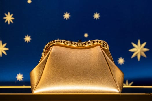 Florence, Italy - 12.01.2023: Elegant golden Bulgari handbag display with starry night background for fashion design.