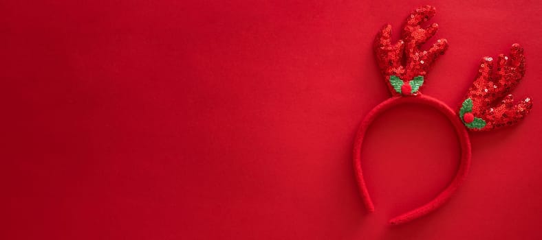 Colorful reindeer antlers headband. Holiday costume detail. Creeting card. Horn of a Christmas deer. New Year decoration on hair. Top view, flat lay, banner