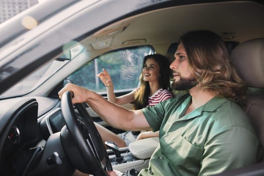 A joyful moment inside a car, featuring a man and woman, with city scenery visible through the windows