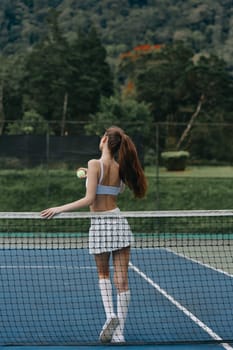 Active female tennis player in a stylish outfit enjoying a sunny afternoon on a vibrant blue court, embodying fitness and outdoor sports