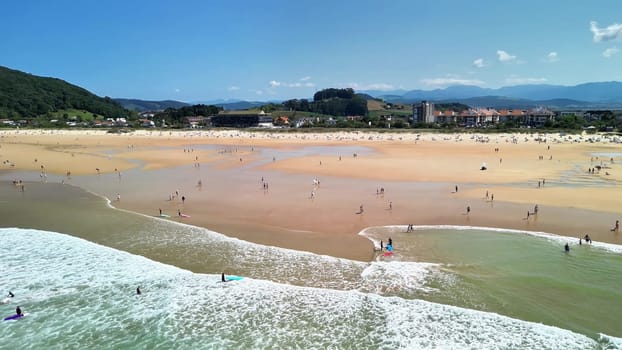 A lively beach scene with crashing waves, surfers, and joyful beachgoers enjoying the sun and soft sand