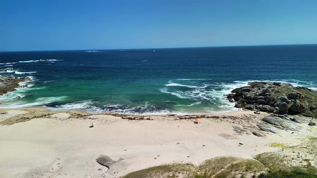 Witness a breathtaking view of a tranquil beach featuring clear waters and gentle waves beneath a radiant sunny sky