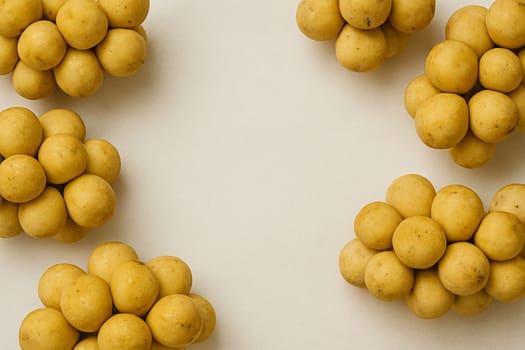 AI generated vibrant image of golden longkong fruits arranged in circular formation, showcasing their delicate clustered berries and fresh stems against clean white background