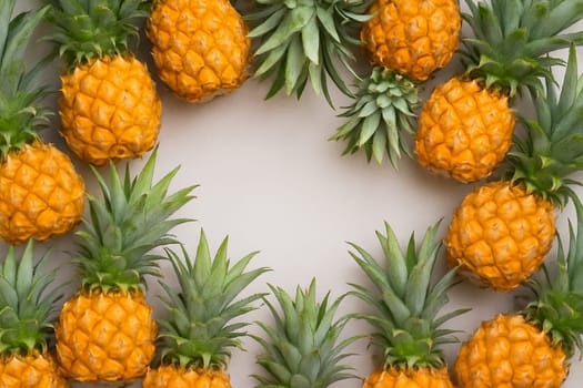 AI generated vibrant image of golden pineapples arranged in circular formation with glistening water droplets, showcasing their spiky crowns and fresh tropical sweetness against clean white background
