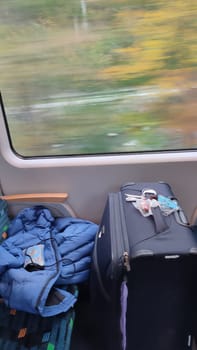 Suitcase travel jacket train sitting windows shotlisttravel travel tourism transport green nature summer . High quality photo