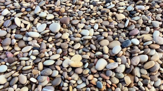 A stunning view of a beautiful pebble beach with clear blue waters and gentle waves lapping the shore