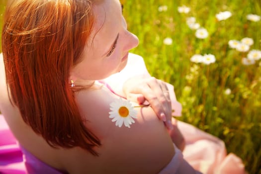 A young woman relaxes in a vibrant meadow, adorned with daisies, a single flower placed gently on her shoulder as she enjoys the warm sunlight.