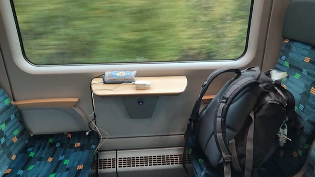 Train seat backpack table objects furniture shotlisttravel travel tourism transport road green nature summer autumn background landscape charging cable . High quality photo