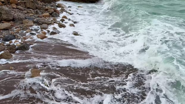 The dynamic ocean waves crashing against the rocky coast create an incredibly serene and picturesque coastal scene