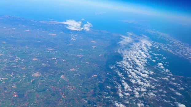 A breathtaking and captivating perspective of Earth showcasing both clouds and land from a notably high altitude