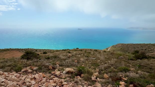 Enjoy a breathtaking view from a scenic hilltop that overlooks stunning turquoise waters and rocky terrain