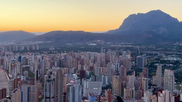 Witness a breathtaking view of a stunning coastal city slowly awakening to the beautiful colors of sunrise