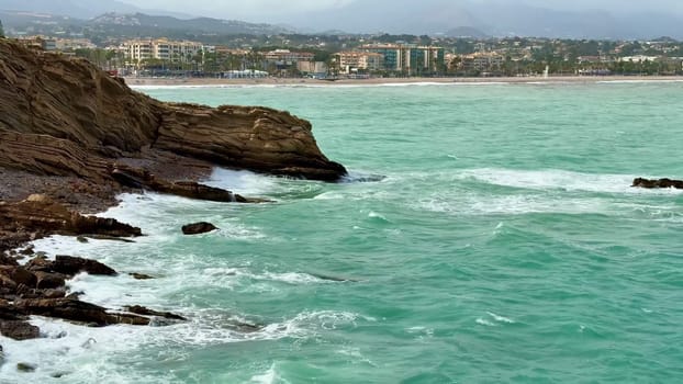 A breathtaking coastal scene showcasing vibrant turquoise waters along with a stunning city skyline visible