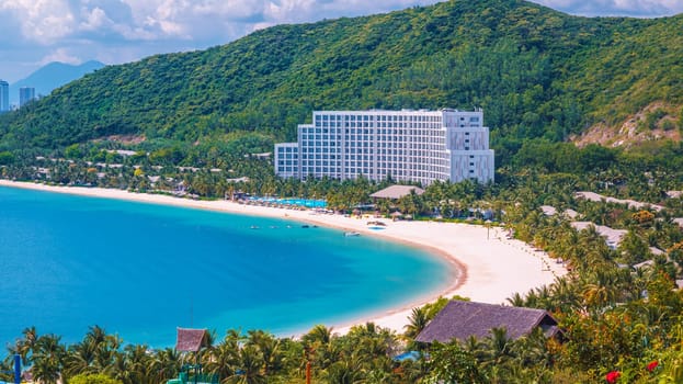 Luxury seaside hotel at sea with sandy beach in Hon Tre island in Nha Trang in Vietnam, top aerial view. A resort in Asia