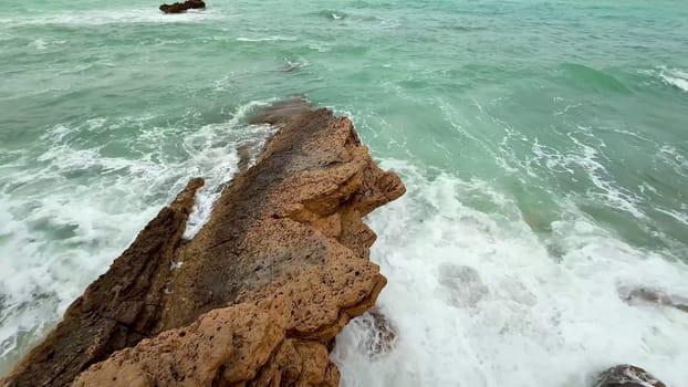 Waves crash against rocky outcrops, creating a tranquil coastal scene. Perfect for nature enthusiasts.