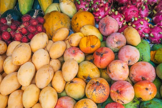 assortment of fresh Asian exotic tropical fruits and mangoes on the counter at Asian street market in Thailand