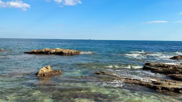 This striking and tranquil seaside scene beautifully showcases rocky formations along with the crystalclear waters