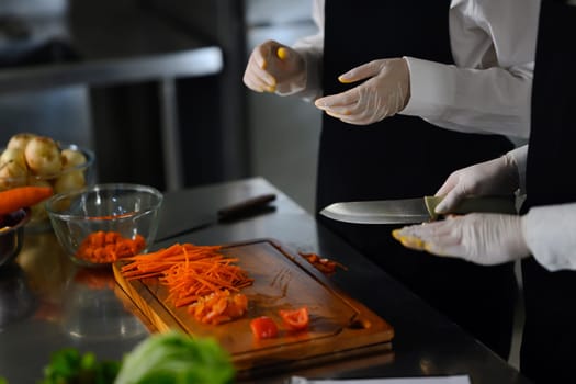 Cooking students slicing vegetables during a cooking class.