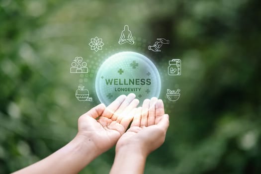 Wellness and longevity infographic over human hand with green blurred background..