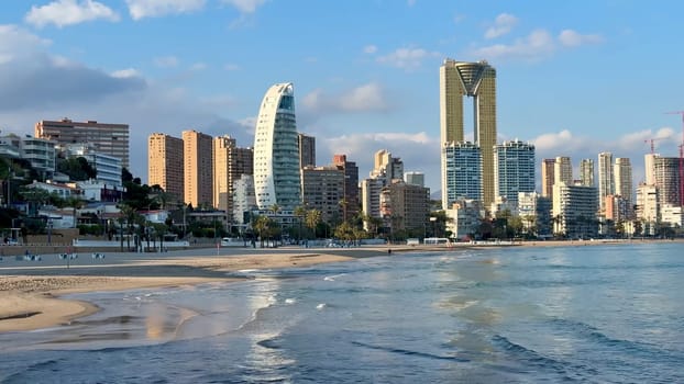 Discover the breathtaking skyline of Benidorm, featuring its iconic highrises alongside tranquil beach waters