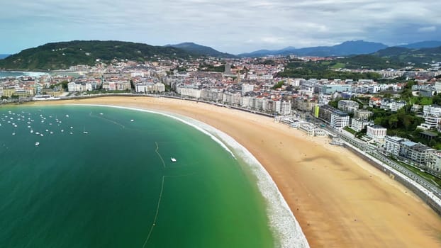 Experience the stunning aerial view of a vibrant coastal city by the serene beach, combining nature and urban life