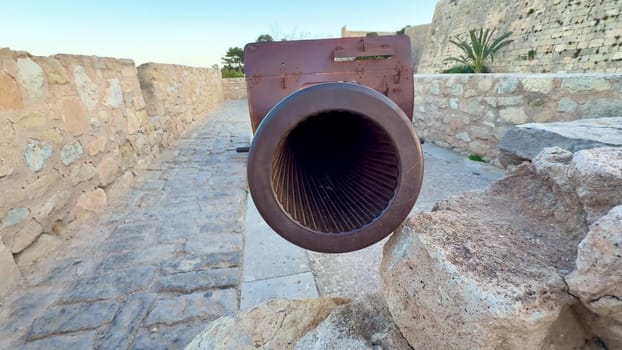 Closeup of a historic cannons ornate barrel in a majestic stone fortress, showcasing its intricate design