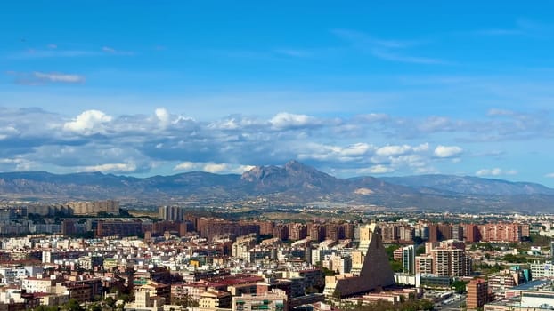 The city skyline is vibrant, showcasing majestic mountains under a bright blue sky, perfect for urban themes