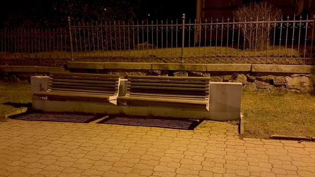 A solitary park bench, softly illuminated at night, beautifully highlights subtle urban tranquility and peace