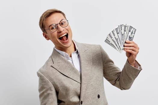 excited young caucasian man wear beige plaid jacket hold us dollar bills smiling celebrating financial success freelance income online work digital nomad lifestyle concept of freelancing and remote work