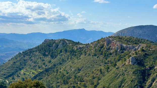 Stunning mountain scenery featuring rolling hills and clear blue skies, ideal for nature enthusiasts.