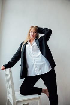 Fashionable Woman in Black Men's Suit Sitting on Chair Portrait