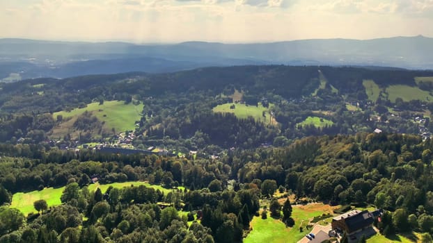 A stunning landscape highlights rolling hills and valleys, showcasing the natural beauty beneath a cloudy sky