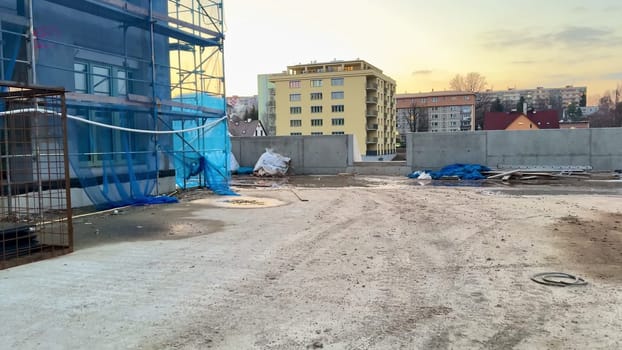 A construction site showcasing several unfinished buildings set against a beautiful, vibrant sunset sky backdrop